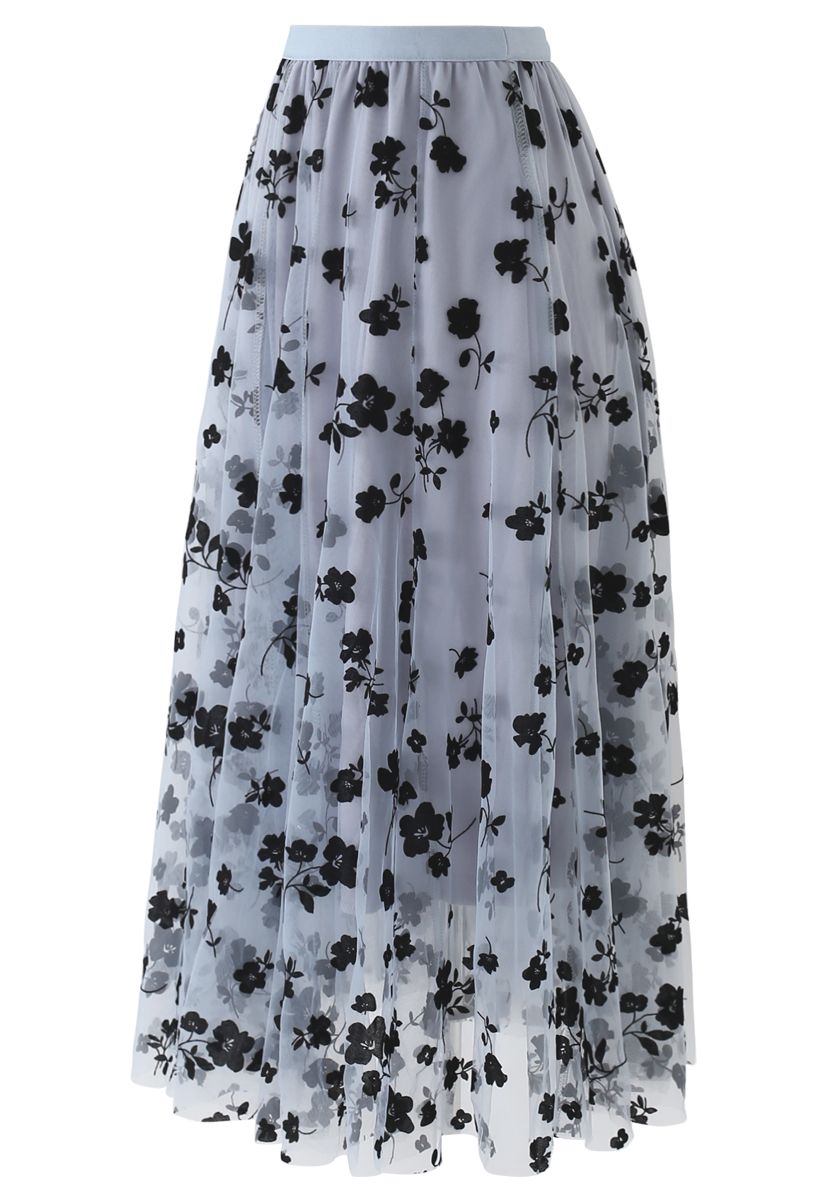 Front view of a flowy dusty blue mesh midi skirt adorned with black floral designs, creating a romantic look.