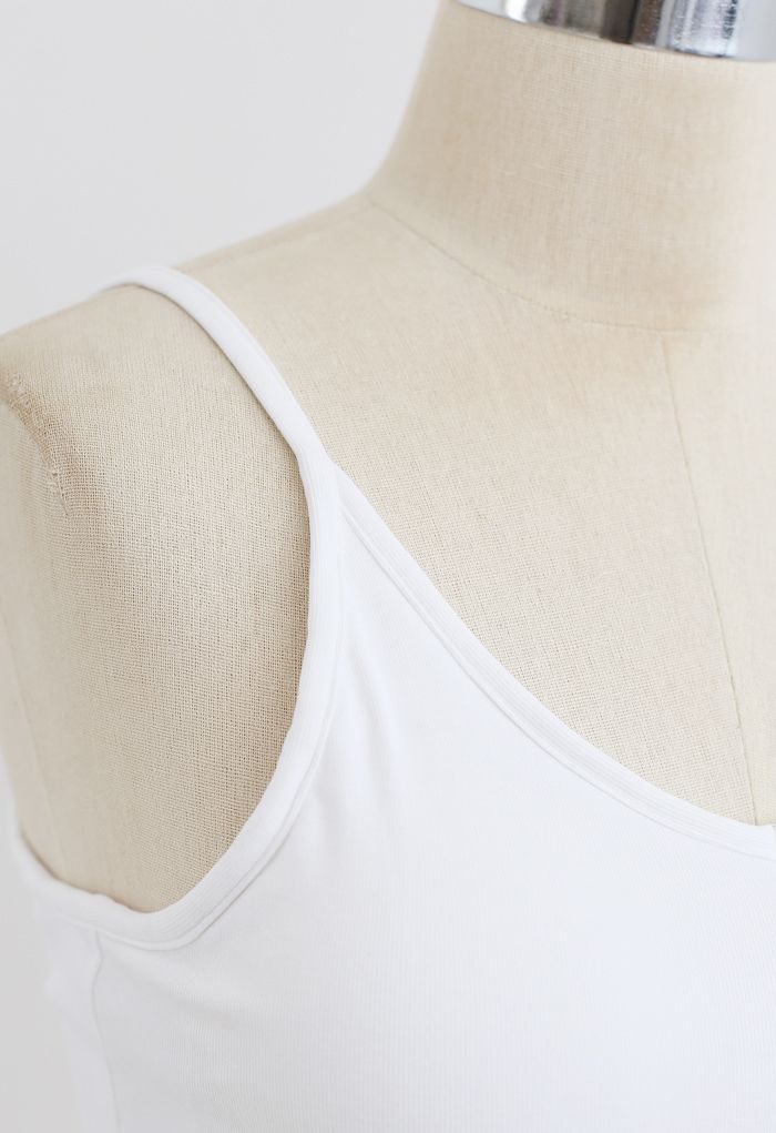 Detail shot of a white cropped rib cami tank top, highlighting the thin straps and ribbed texture.