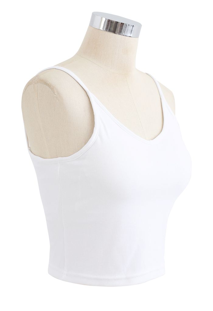 Side view of a white cropped rib cami tank top on a mannequin, emphasizing its fitted and casual style.