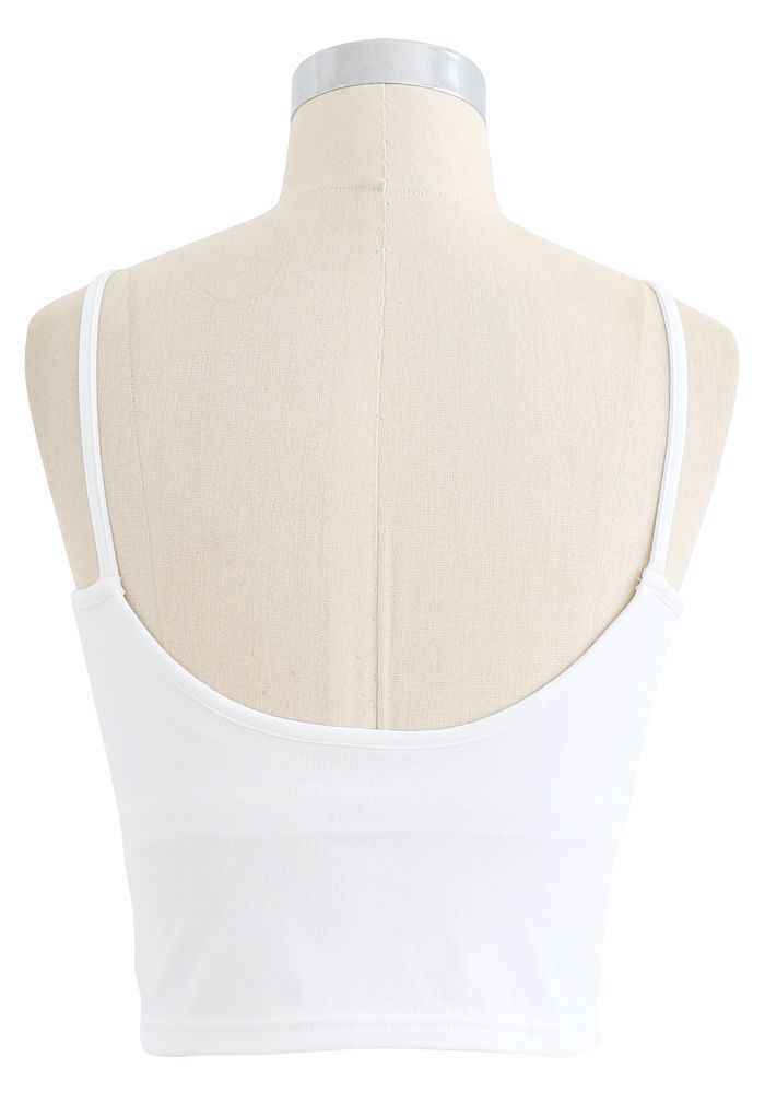 Back view of a white cropped rib cami tank top on a mannequin, displaying the simple and sleek design.