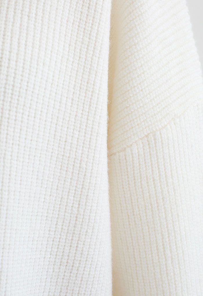 Detail shot of the white knit fabric of the sweater, showcasing its texture.