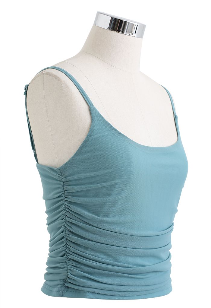 Side view of a teal ruched soft mesh cami top on a mannequin, emphasizing its flattering fit and delicate straps.