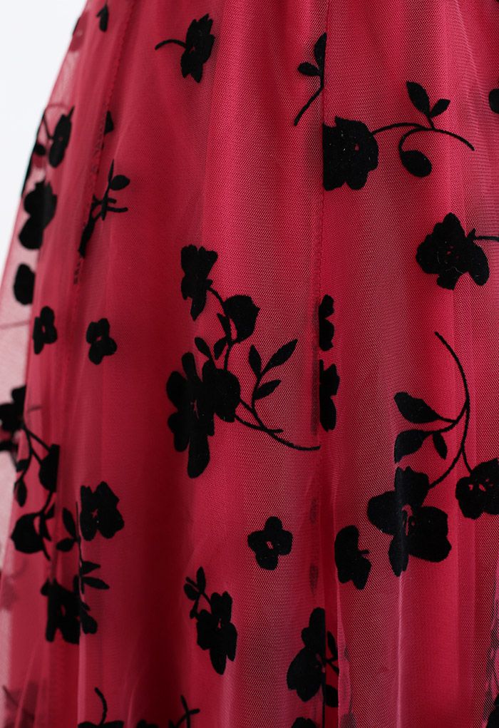 Close-up detail of the red 3D posy mesh skirt showing intricate black floral patterns.