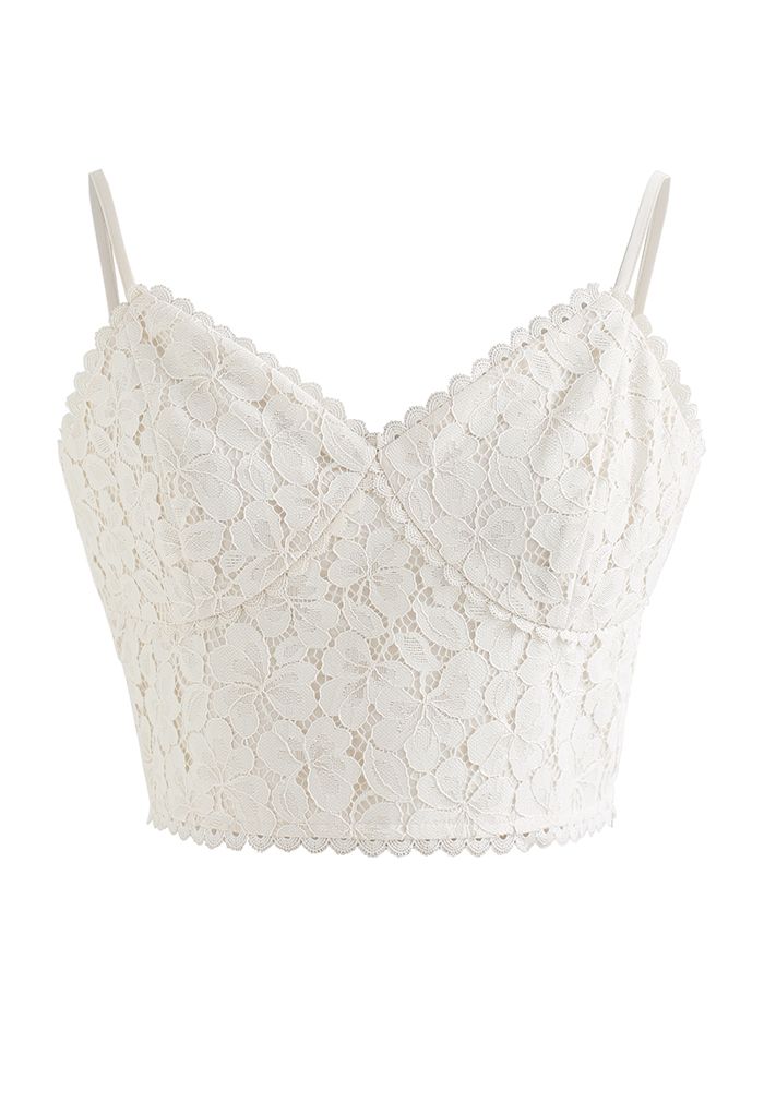 Front view of a delicate white lace crop cami top with thin straps and a scalloped edge.