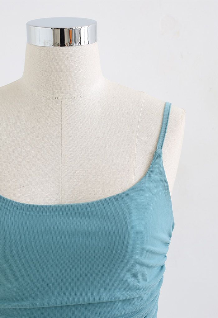 Close-up front view of a teal ruched soft mesh cami top on a mannequin, highlighting its elegant design.