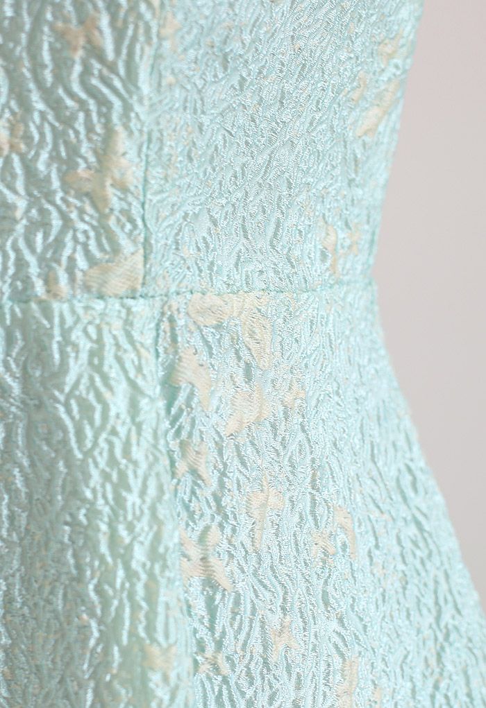 Detail shot of the blue cami midi dress highlighting the intricate butterfly embroidery and textured fabric.
