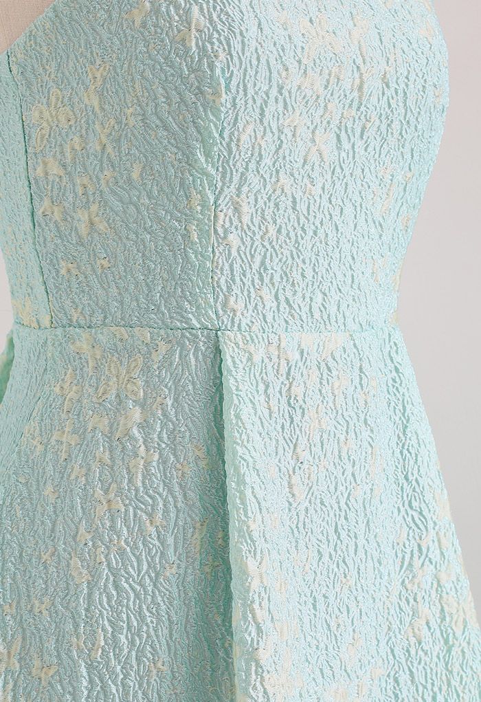 Close-up of the side of the blue cami midi dress, displaying the embossed butterfly pattern.