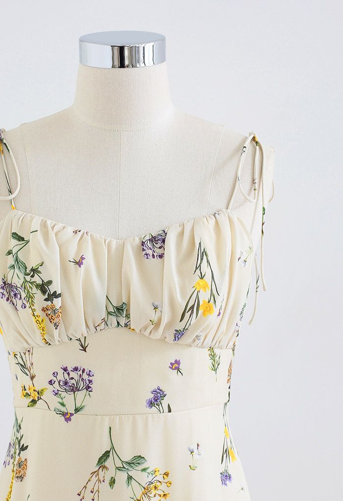 Detail shot of the bodice on a dress form, showcasing the floral print and tie straps.