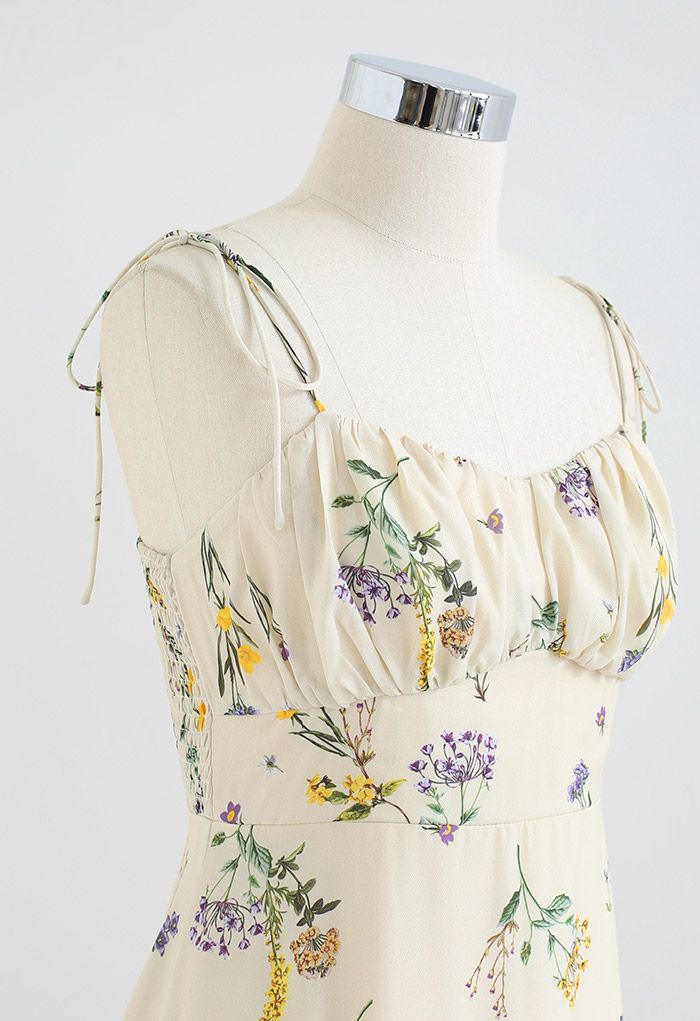 Side detail shot of the dress on a mannequin, highlighting the floral print and tie straps.