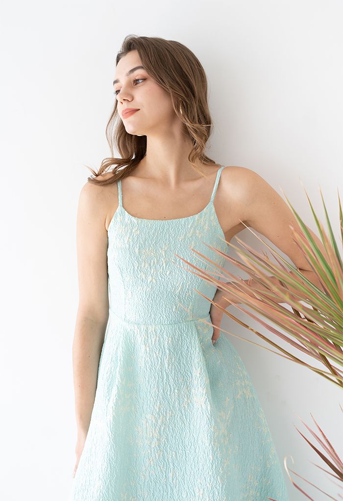 Front view of a woman wearing a romantic, light blue midi dress with butterfly embroidery and thin straps.