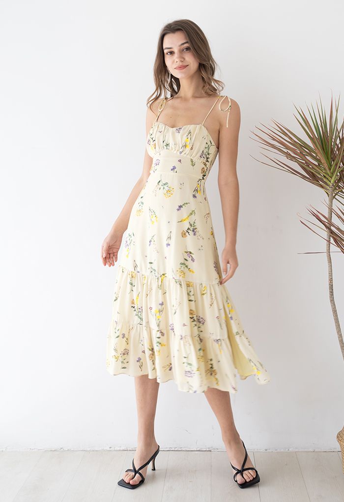 Model posing in the dress, highlighting its flowy skirt and delicate floral pattern.