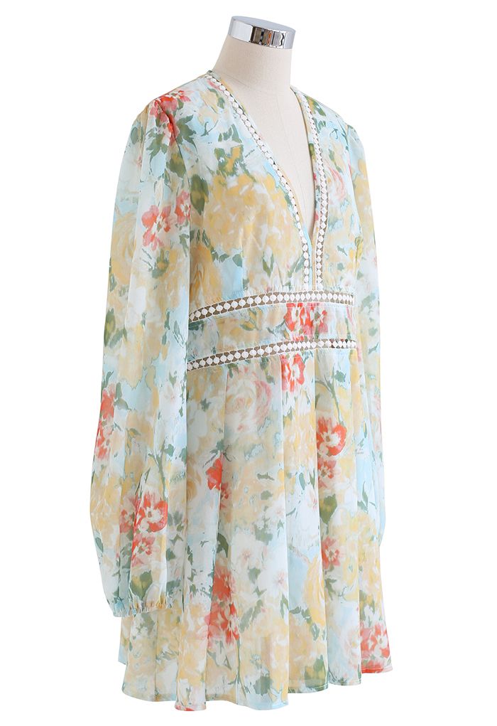 Side view of a flowy, floral long sleeve dress with a deep V-neck and lace detailing, showcasing a vibrant yellow pattern.