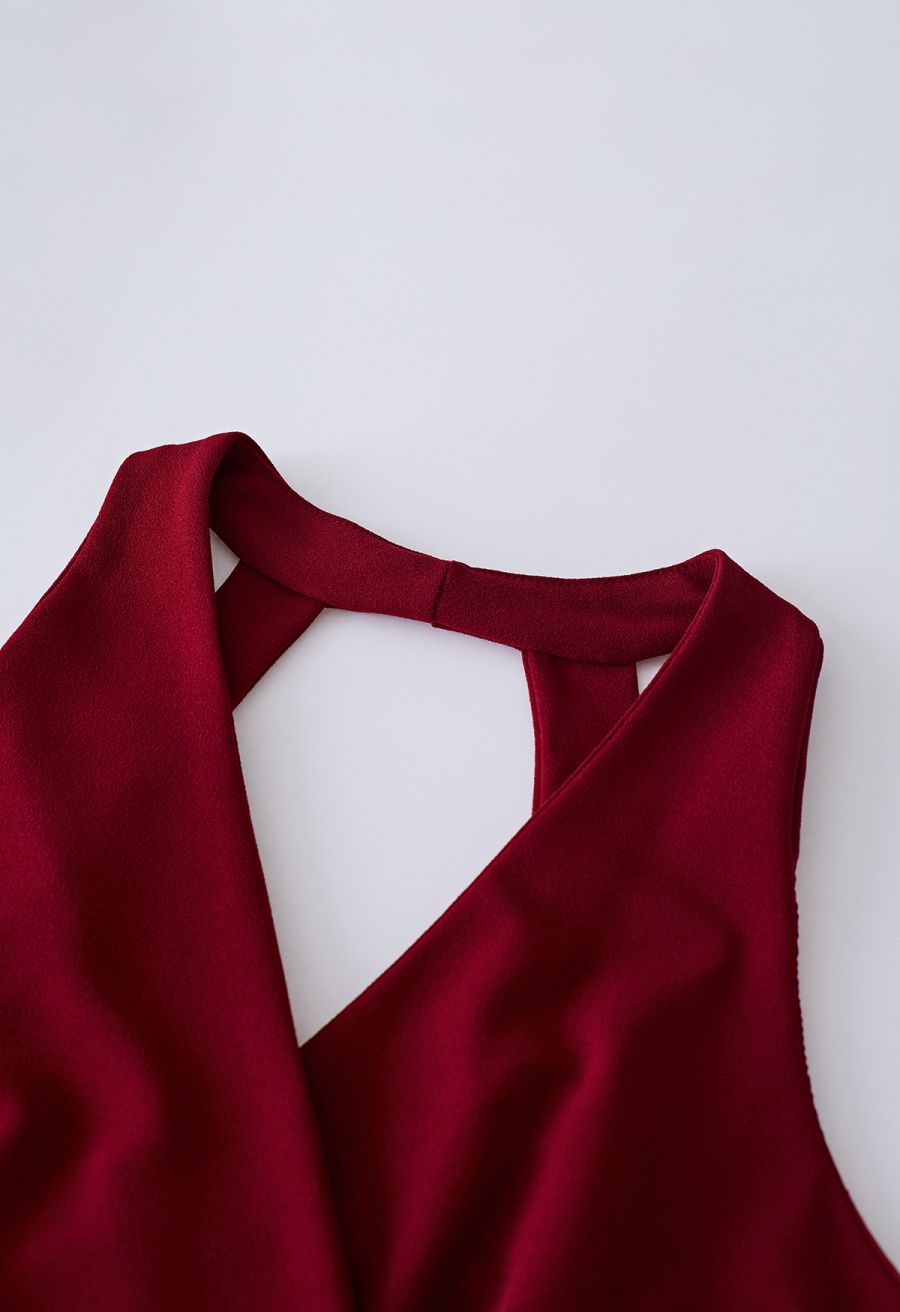 Detail shot of the neckline of a burgundy dress, highlighting the elegant V-neck design.
