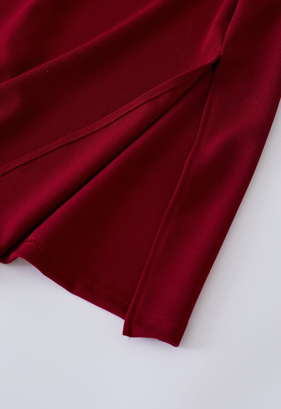 Detail shot of a burgundy dress fabric showcasing a smooth and elegant texture.