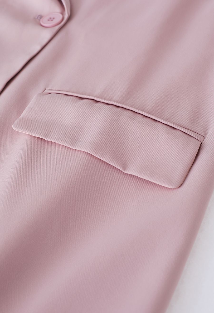 Detail shot of a pink blazer pocket, emphasizing the smooth fabric and tailored design for a chic look.