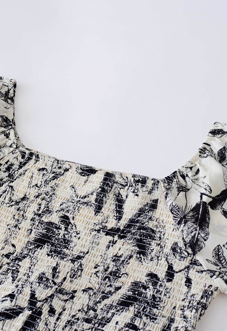 Detail shot of the square neckline and smocked bodice of the inky botanical print midi dress.