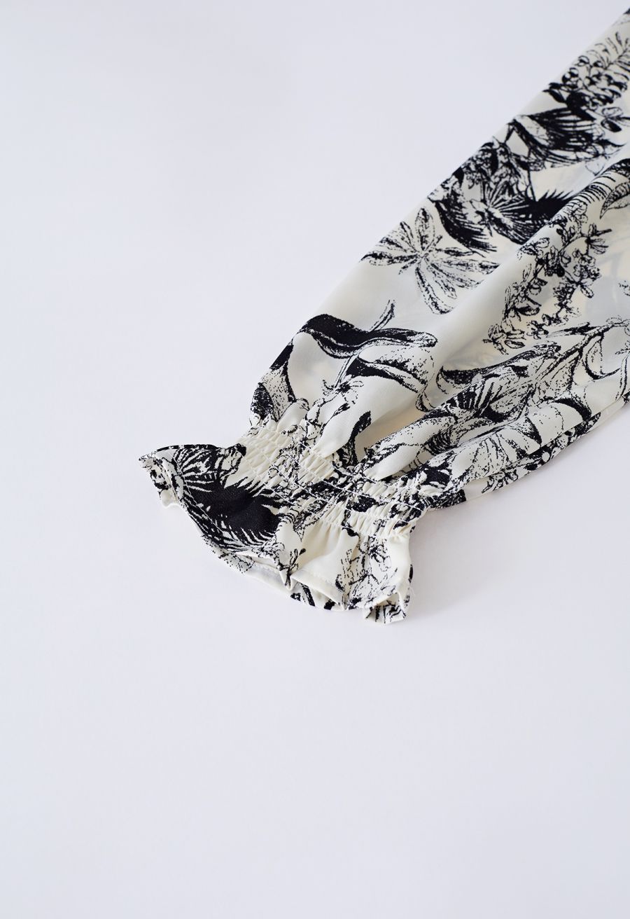 Detail shot of the long sleeve with a ruffled cuff on the inky botanical print midi dress.