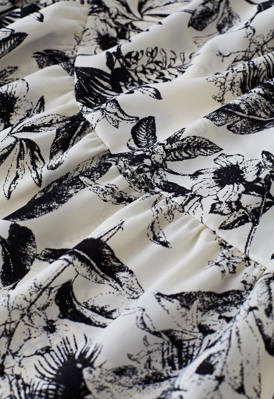 Detail shot of the delicate floral pattern on the flowing fabric of the inky botanical print midi dress.
