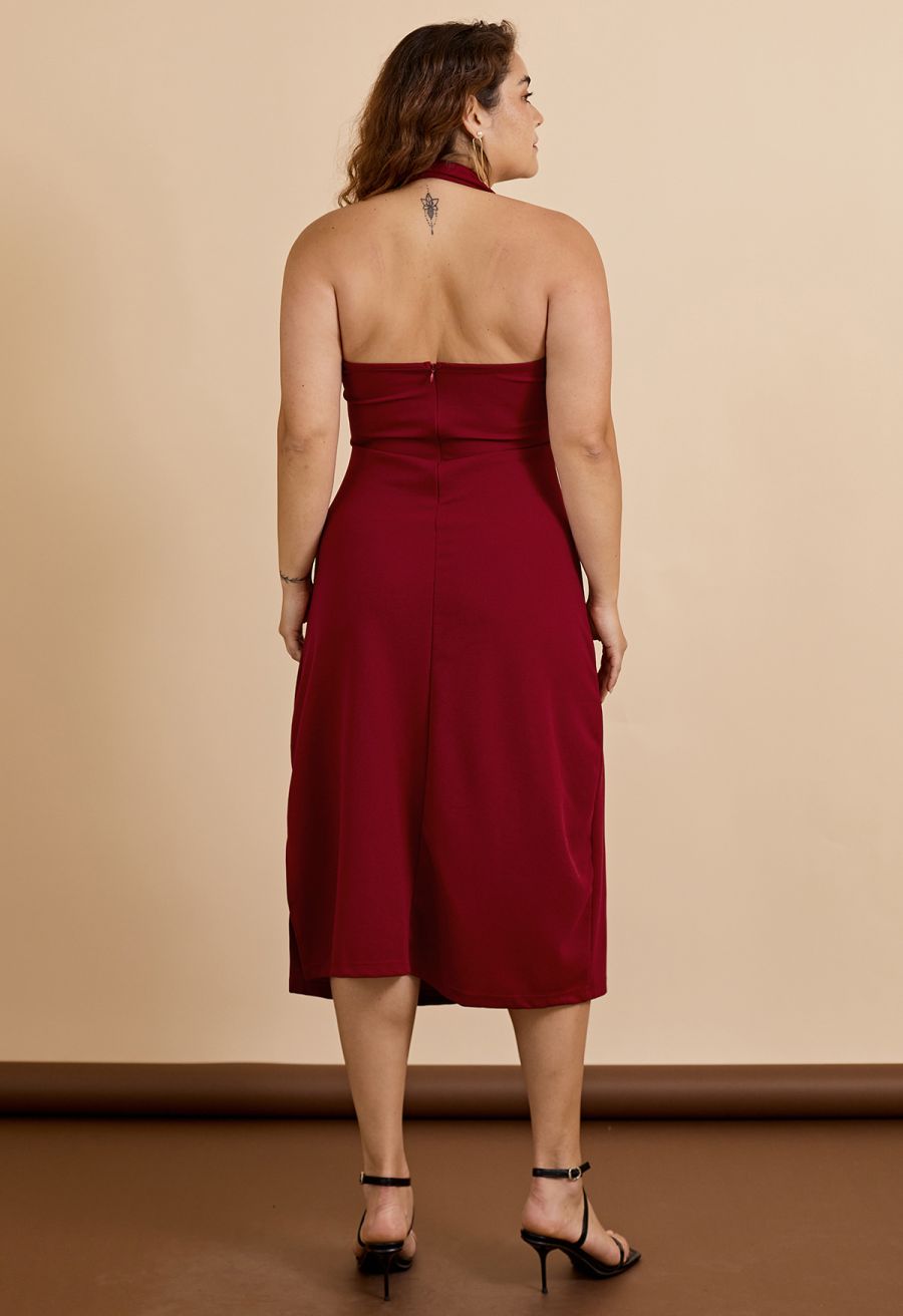 Back view of a woman wearing a burgundy halter neck wrap bust dress, highlighting the elegant back design.