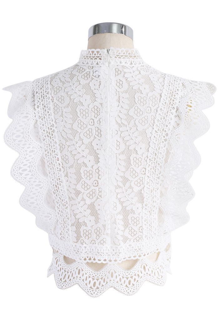 Back view of a vintage-inspired white sleeveless crochet lace top featuring delicate floral designs and scalloped trim.