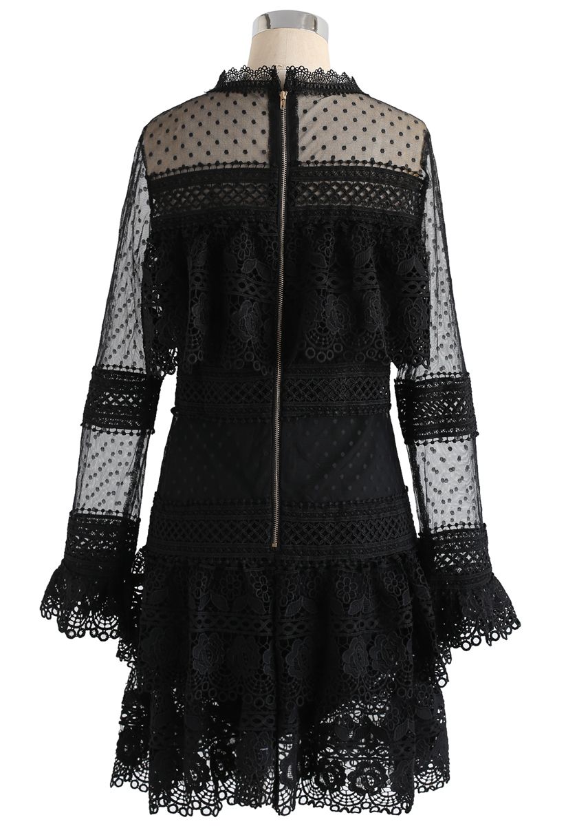 Back view of a black crochet mesh dress featuring a zipper and delicate lace detailing, creating a sophisticated and timeless appearance.